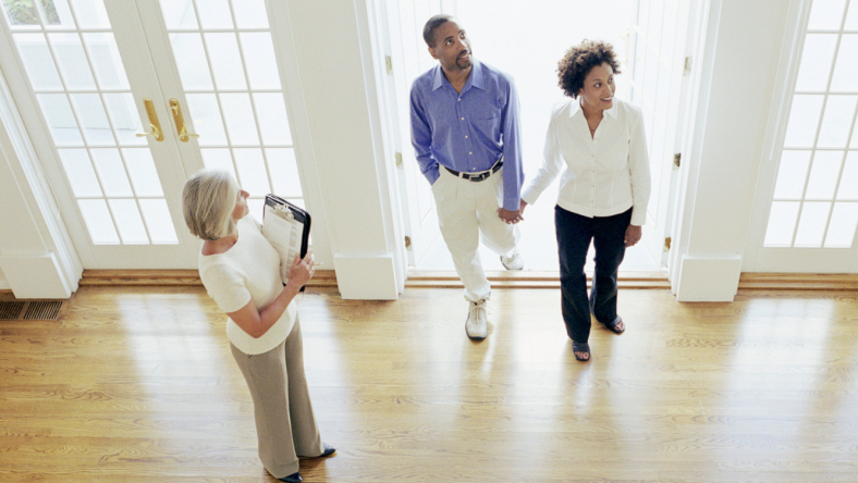 A couple looking around a new house with a realtor