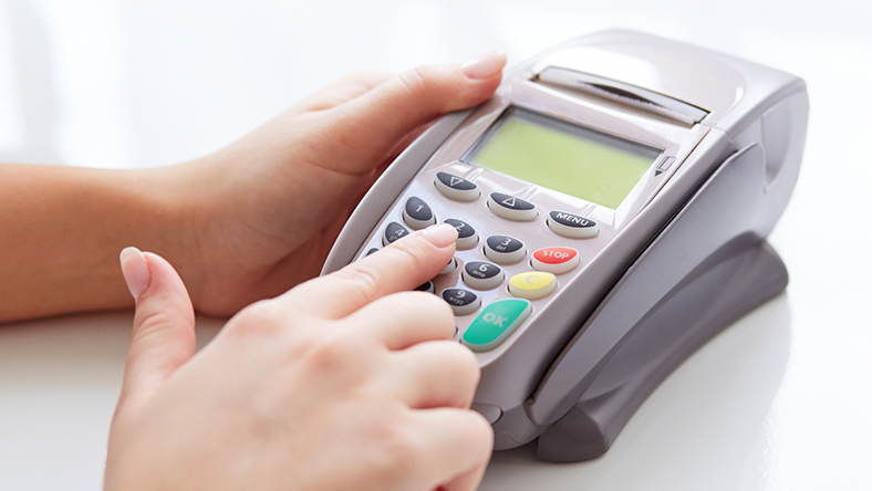 A woman entering her pin on a card reader