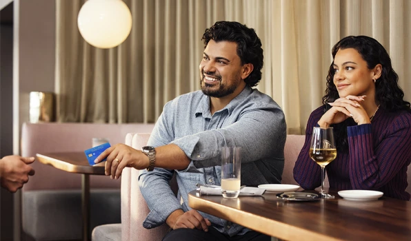 Customer using a debit card to pay at a restaurant, illustrating the convenience, value, and exclusive benefits available through Club Five membership.