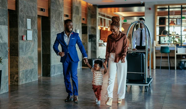 Travelers with luggage in a hotel lobby, illustrating lifestyle, travel, and exclusive member benefits through Club Five.