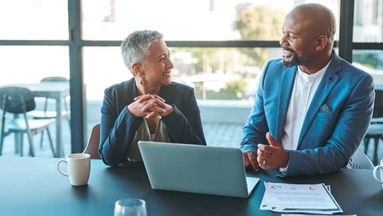 Two business colleagues at table with laptop