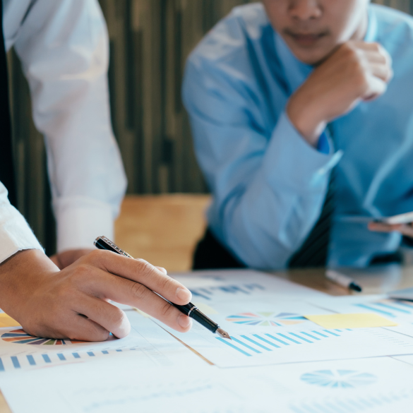 Close up of businessmen reviewing graph charts.