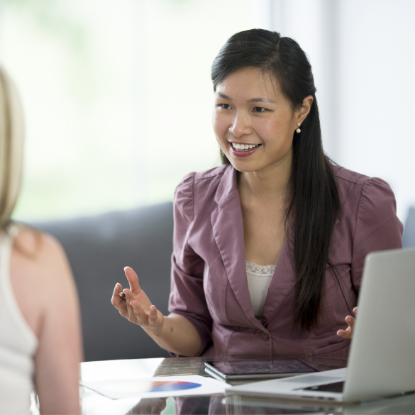 Woman smiling while sitting at desk with laptop and papers