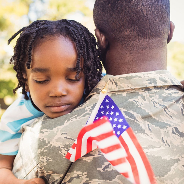 Veteran father holding young daughter with U.S. Flag