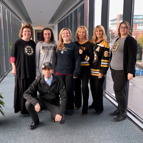 Seven Salem Five employees wearing Bruins fan clothing.