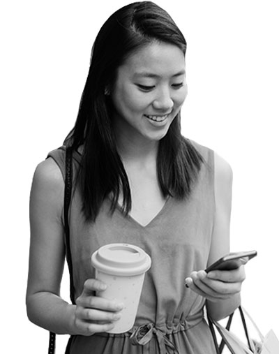 Woman holding mobile device and coffee